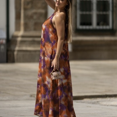 Vestido longo colorido abstrato em tecido fluído num ambiente urbano