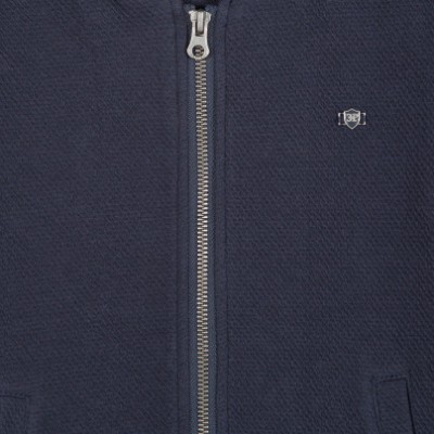 Casaco azul escuro com fecho de correr prateado e logótipo metálico