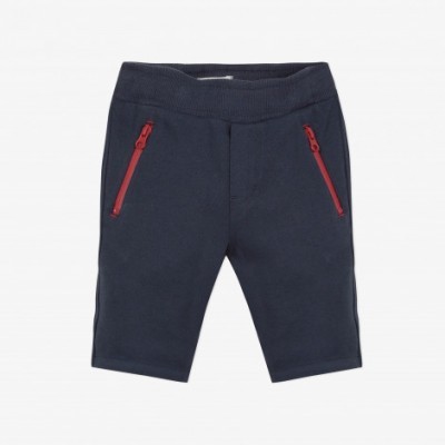 Calções de criança azul escuro com fechos vermelhos.