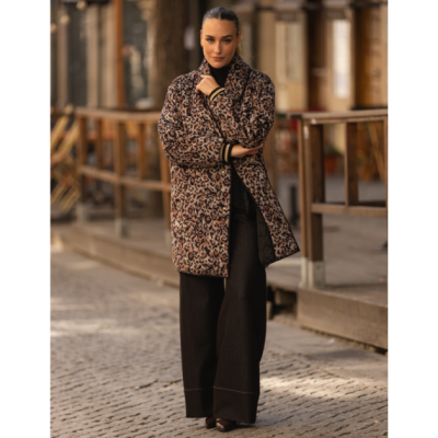 Casaco comprido padrão animal print castanho e preto com calças largas pretas em ambiente urbano