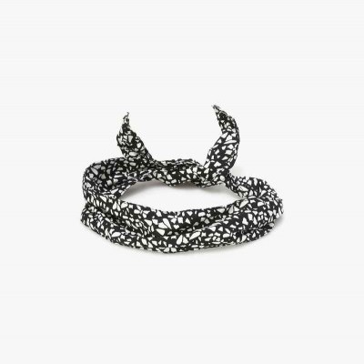 Laço de cabelo preto com padrão branco em tecido, sobre fundo branco