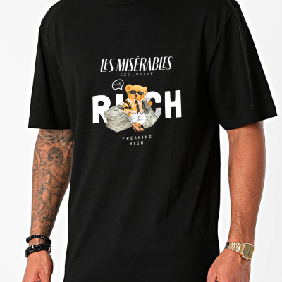 T-shirt preta com estampa de urso e textos, usada por homem com tatuagens e relógio