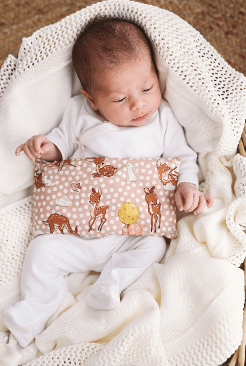 Almofada térmica S Bebé com almofada decorada com cervos e coelhos num ambiente acolhedor