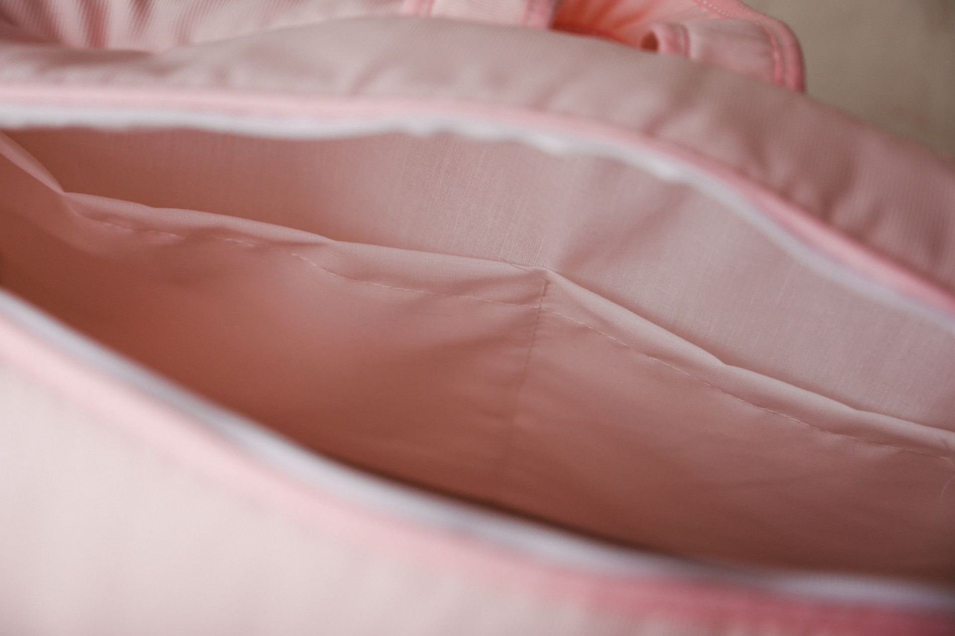 Mala de maternidade Interior de uma mala rosa com tecido liso e compartimento espaçoso