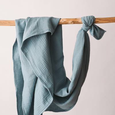 Lenço azul claro com textura pendurado em pau de madeira