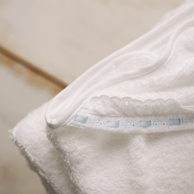 Roupa interior branca com renda sobre toalha branca felpuda