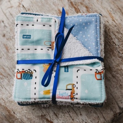 Conjunto de panos coloridos com padrão de caminhos e carros, amarrados com fita azul