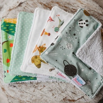 conjunto de cinco panos com padrões e cores variadas sobre madeira clara