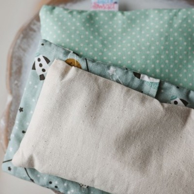 Almofadas ou sacos de tecido azul claro com padrões e etiquetas