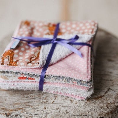 Conjunto de panos coloridos amarrados com fita azul sobre tábua de madeira