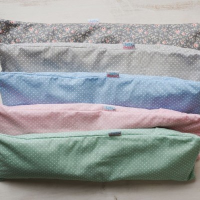 Cinco almofadas retangulares com padrões florais e de bolinhas em várias cores