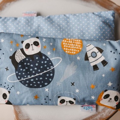 Mini almofada azul com pandas e planetas sobre cadeira de madeira clara