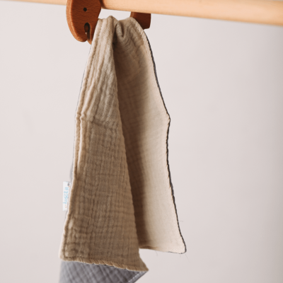 Pano de duas cores pendurado em suporte de madeira numa barra