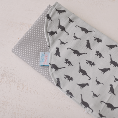fralda de bebé cinzenta com padrão de dinossauros e bolinhas
