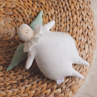 Peluches em forma de anjo branco com asas verdes em superfície trançada