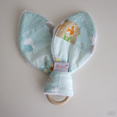 Chocalho ou mordedor com argola de madeira e tecido azul com padrões