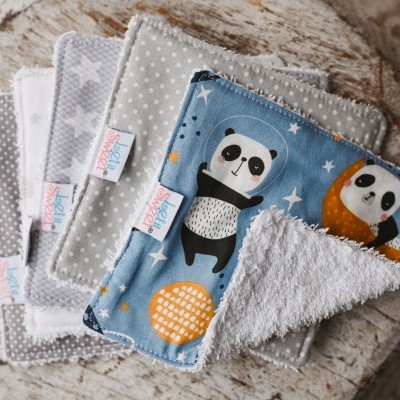 panos de limpeza para bebé com estampas de pandas, estrelas e pontos sobre fundo madeira