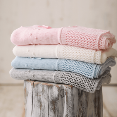 Quatro mantas coloridas empilhadas sobre um tronco de madeira