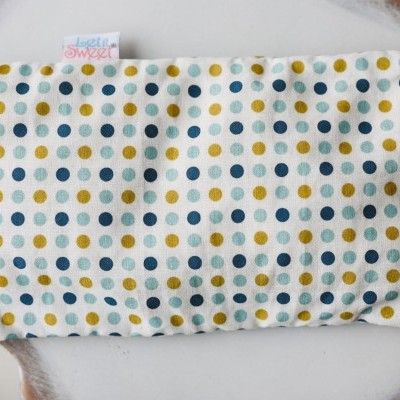 Almofada retangular com padrão de pontos coloridos sobre prato branco