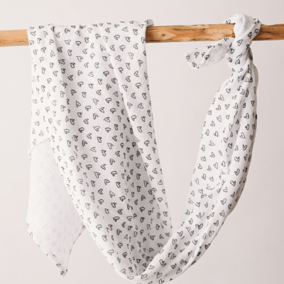 Lenço branco com corações pretos pendurado numa barra de madeira