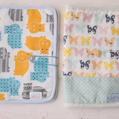 Dois porta-documentos para bebé com padrões coloridos de hipopótamos e borboletas