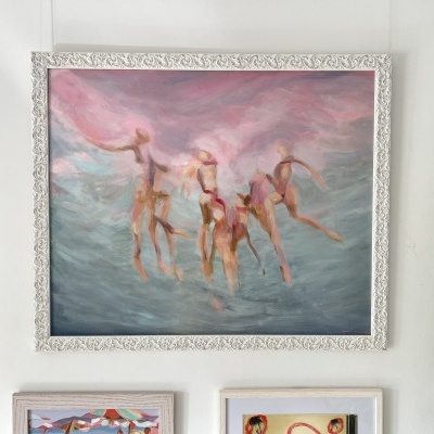 Quadro pintado com moldura branca e figuras humanas abstratas em tons rosa e azul