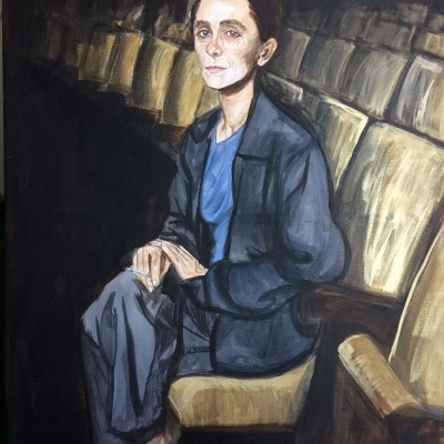 Retrato de mulher sentada numa cadeira estofada bege