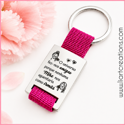 Chaveiro com fita rosa e placa metálica com texto e desenhos em fundo branco com flores cor-de-rosa