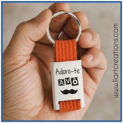 Porta-chaves com fita laranja e base branca com texto Adoro-te AVÔ e bigode preto