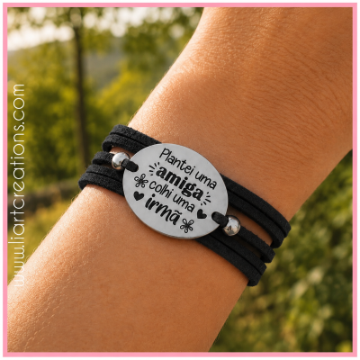 Pulseira preta com placa metálica oval gravada com texto em português