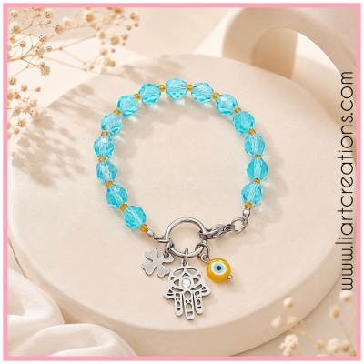 Pulseira azul com contas e pendentes prata numa superfície clara
