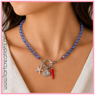 Colar azul com pingentes metálicos prateados e vermelho, visto no pescoço de uma mulher.