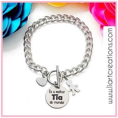 Pulseira prateada com pendentes de coração, boneco e disco com texto em fundo branco e flores coloridas