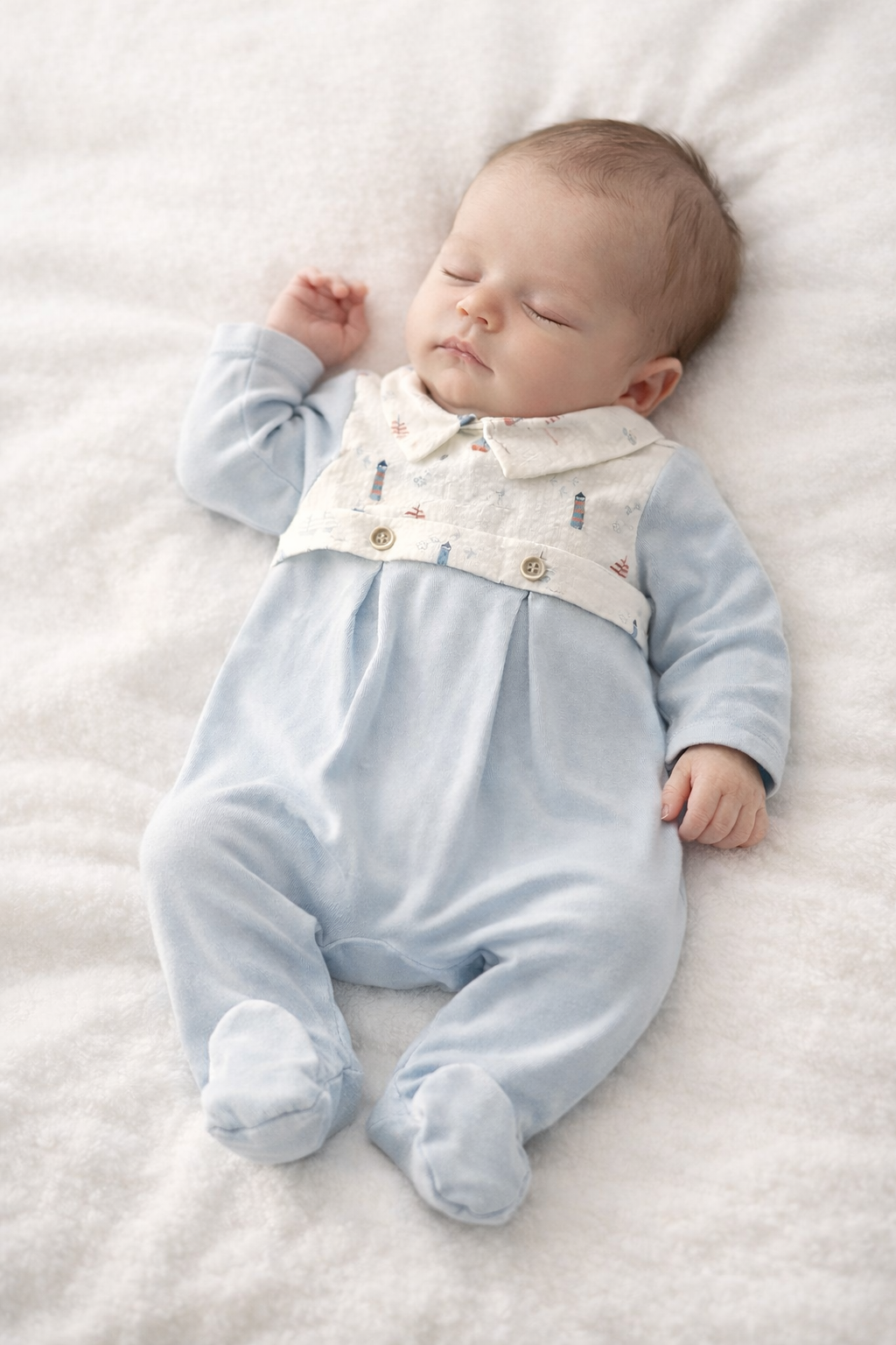 Babygrow 'Blue Sea' com peitilho e gola Bebé deitado a dormir com macacão azul claro e branco