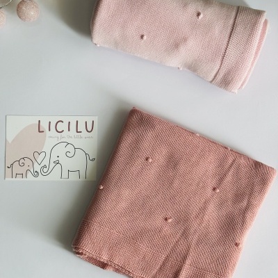 Duas mantas de malha rosa com textos e ilustração de elefantes num cartão