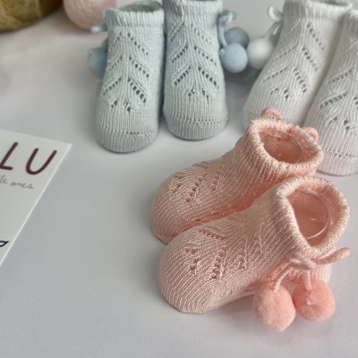 Meias de bebé tricotadas em rosa e azul com cartão de marca