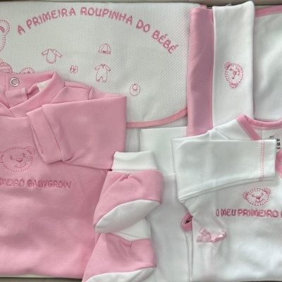 Conjunto de roupa de bebé rosa e branco com bordados de ursinho e textos em português.
