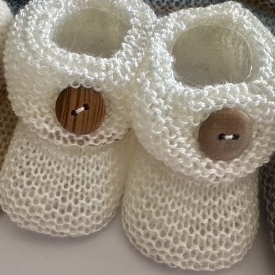 Sapatilhas de bebé brancas em malha tricotada com botões de madeira