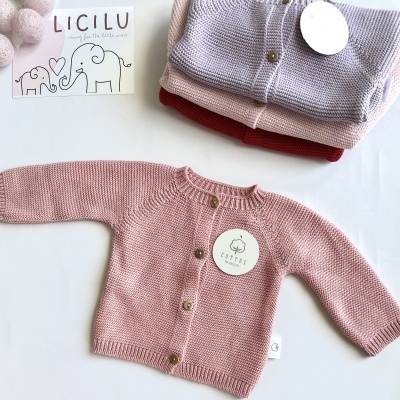 Casacos de malha para bebé em rosa, vermelho e lilás com botões e etiquetas da marca NATTER