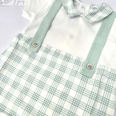 Macacão de bebé branco com padrão xadrez verde e branco e alças verdes com botões