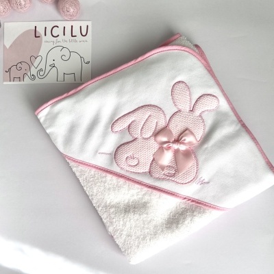 Toalha de bebé branca com bordas rosas e bordado de coelhos com laço cor-de-rosa.