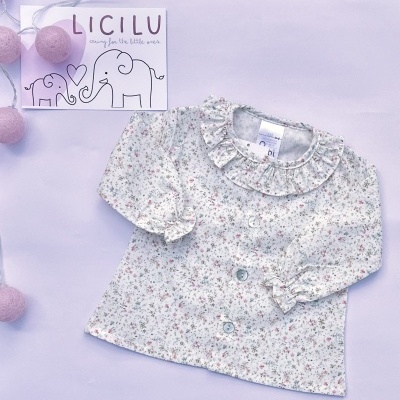 Casaco de bebé branco com padrão floral pequeno e folhos, luzes rosa e cartão com elefantes