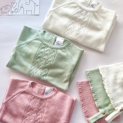 Camisolas e babetes de bebé em malha nas cores branca, verde claro e rosa com padrão rendilhado.