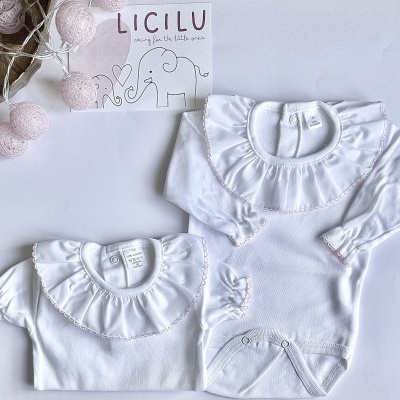 Dois bodies brancos para bebé com gola rodada e folhos, guirlanda cor-de-rosa e cartão LICILU