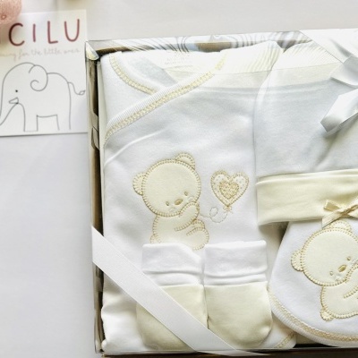Conjunto para bebé LICILU com toalha, babete e touca brancos com bordados de ursinhos e corações em bege numa caixa com laço