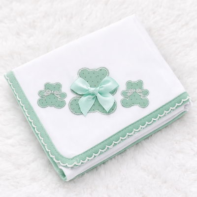 Manta branca com bordas verdes e três ursinhos verdes aplicados