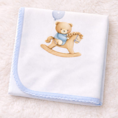 manta branca com bordas azuis e ursinho com cavalo de pau