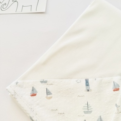 Toalha de bebé branca com detalhe estampado de barcos e farol