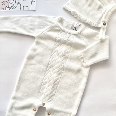 Macacão e boné de bebé brancos em malha com botões castanhos e cartão com desenho de elefantes.