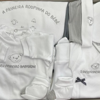 Conjunto de roupa branca e cinzenta de bebé com estampas de ursinho e texto em português.